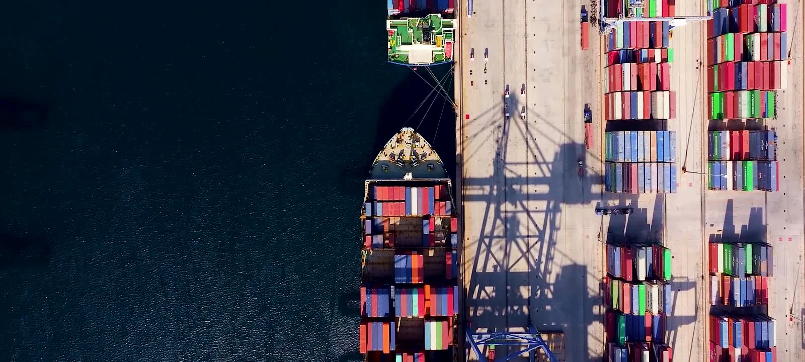 Overhead view of a container ship being worked by quay cranes
